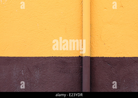 eine Rinne auf einer gelben und braunen Wand Stockfoto