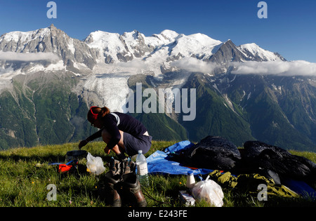 Eine Dame Camper Vorbereitung Essen wildes Campen auf le Brévent in den französischen Alpen mit dem Mont-Blanc-Massiv über Stockfoto