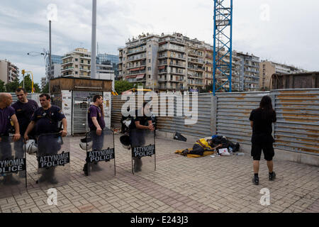 Thessaloniki, Griechenland. 15. Juni 2014. Ein Obdachloser schläft nächsten Polizisten während der antifaschistischen Demonstration gegen Golden Dawn in Thessaloniki, Griechenland. Extremen Rechten Golden Dawn Partei ein ehrenamtliche Event organisieren für Alexander der große in der nördlichen Hafenstadt Thessaloniki Griechenland. Golden Dawn, gewann fast 9,39 Prozent der Stimmen im Mai 25 Wahlen und 3 Sitze im Europäischen Parlament. Bildnachweis: Konstantinos Tsakalidis/Alamy Live-Nachrichten Stockfoto