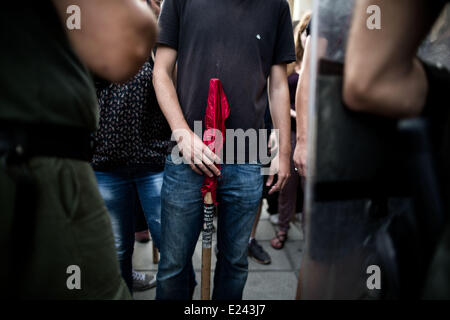 Thessaloniki, Griechenland. 15. Juni 2014. Ein Mann hält eine rote Fahne vor Aufruhr Polizisten blockieren die antifaschistischen Demonstranten die Golden Dawn-Rallye zu nähern. Antifaschistische Demonstranten versammelt, um protest gegen Golden Dawn in Thessaloniki, Griechenland... Golden Dawn, gewann fast 9,39 Prozent der Stimmen im Mai 25 Wahlen und 3 Sitze im Europäischen Parlament. Bildnachweis: Konstantinos Tsakalidis/Alamy Live-Nachrichten Stockfoto