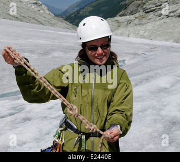 Eine Dame Bergsteiger üben binden Knoten in einem Kletterseil auf einem alpinen Kletterkurs am Ferpecle Gletscher, Schweizer Alpen Stockfoto