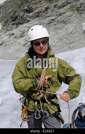 Eine Dame Bergsteiger üben binden Knoten in einem Kletterseil auf einem alpinen Kletterkurs am Ferpecle Gletscher, Schweizer Alpen Stockfoto