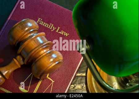 Richter aus Holz Hammer auf "Family Law" Buch mit Waage der Gerechtigkeit Emblem von traditionellen Schreibtischlampe beleuchtet Stockfoto