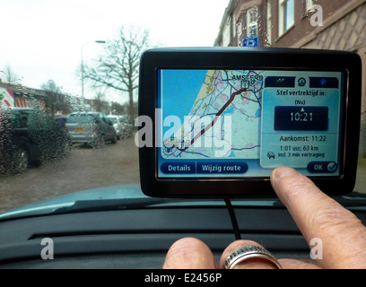 Fahrer im Auto passt seine GPS-System von hand Stockfoto