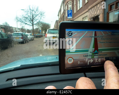 Fahrer im Auto passt seine GPS-System von hand Stockfoto