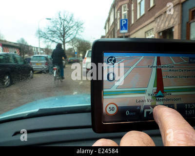 Fahrer im Auto passt seine GPS-System von hand Stockfoto