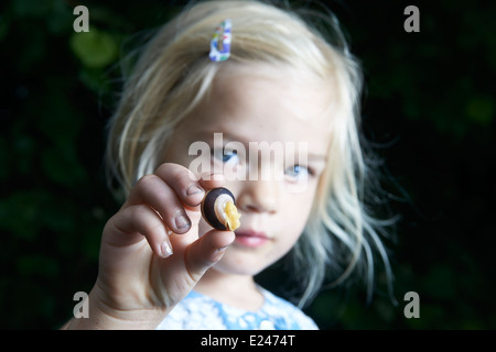 Abenteuer im Garten, Kind blonde Mädchen zeigen und lernen kleine Schnecke draußen im Sommer Hof Stockfoto