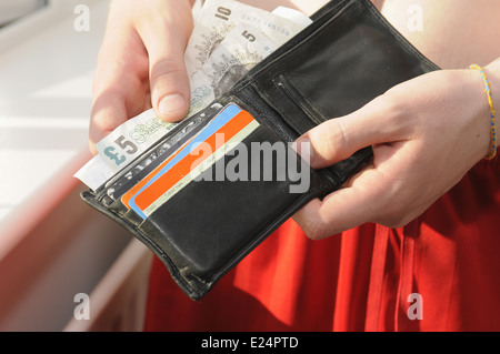 Teenager Cash seine Brieftasche gesucht Stockfoto