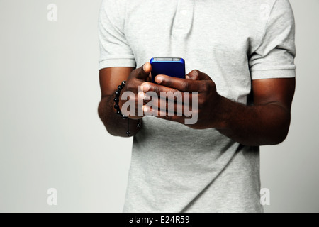 Closeup Portrait von einem männlichen Händen mit Smartphone auf grauem Hintergrund Stockfoto
