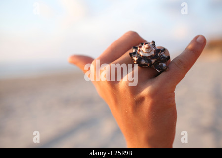 Zarte Frauenhand trägt einen Shell-ring Stockfoto