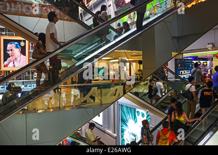 Rolltreppen und Shopper im Einkaufszentrum MBK Center (Mahboonkrong) in Siam Plaza-Bereich von Bangkok, Thailand. Stockfoto
