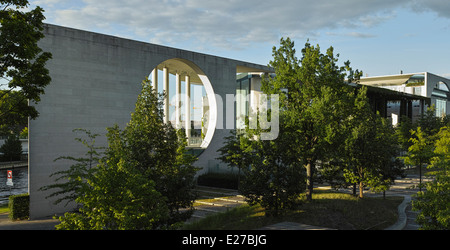 Seitlicher Blick auf das Bundeskanzleramt, das Gebäude für die deutsche Kanzlerin. Abendstimmung mit Bäumen im Vordergrund. Stockfoto