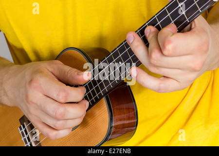 Die Hände des Mannes spielt ukulele Stockfoto