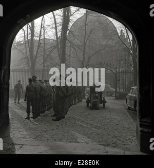 1950er Jahren und ein am frühen Morgen militärischen Aufgebot von Soldaten mit Kanone in einem Innenhof in der Nähe von St. Pauls Cathedral, London, England Stockfoto