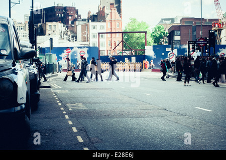 Fußgänger beim Überqueren der Straße bei Tottenham court Road, London, UK Stockfoto