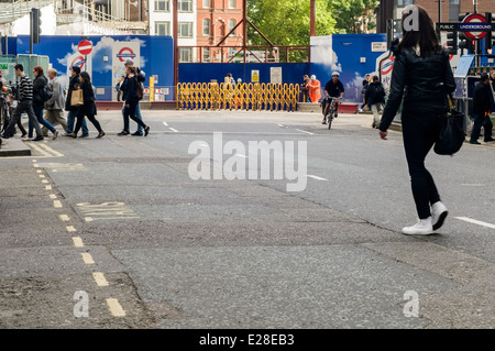 Fußgänger beim Überqueren der Straße bei Tottenham court Road, London, UK Stockfoto