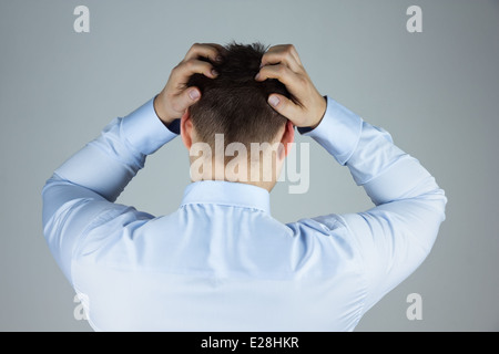 Gestressten Geschäftsmann mit ständigen Kopfschmerzen zurück zu Kamera Stockfoto