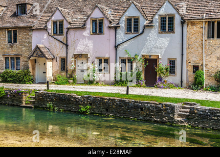 Eine Reihe von ziemlich terrassenförmig angelegten Hütten entlang des Flusses Bybrook in Cotswold Dorf von Castle Combe in Wiltshire. Stockfoto