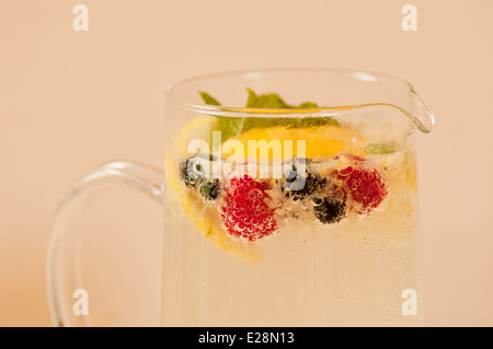 Krug mit hausgemachten prickelnde Limonade mit Sommer Beeren schwimmenden drin Stockfoto