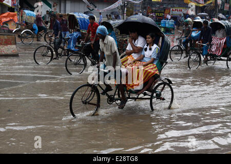 Dhaka, Bangladesch. 17. Juni 2014. Rikscha-Puller befördern Passagiere durch das Hochwasser nach einem starken Regenguss in Dhaka, Bangladesch, 17. Juni 2014. Bildnachweis: Shariful Islam/Xinhua/Alamy Live-Nachrichten Stockfoto