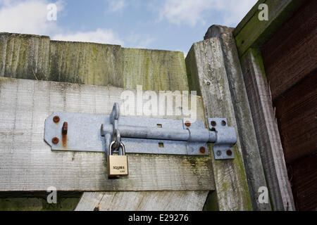 Riegel und Vorhängeschloss am Gartentor, Mendlesham, Suffolk, England, Februar Stockfoto