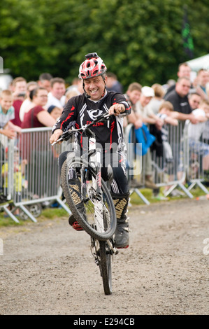 Wheelie Wheelies Mountain Bike Fahrräder Fahrrad Radfahren Mann reitet Fahrer tun einen Sieg feiern festliche ein Rad in der Luft Stockfoto