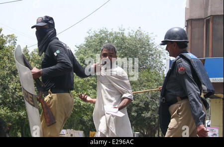 Polizei begleiten einen Mann, der bei Zusammenstößen zwischen Polizei und Fans von Tahir-Ul-Qadri, Leiter einer politischen Partei Pakistan Awami Tehreek in Lahore, auf Dienstag, 17. Juni 2014 verletzt wurde. Mindestens 8 Personen, darunter zwei Frauen wurden getötet und Dutzende wurden verletzt, als Polizei mit den Anhängern von Tahir-Ul-Qadri, kollidierte als Polizei versuchte, die Hindernisse außerhalb Qadris Residenz und Party-Sekretariat in Lahore. Stockfoto