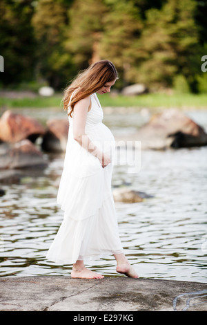 Junge schwangere Frau Hand in Hand auf den Bauch Stockfoto