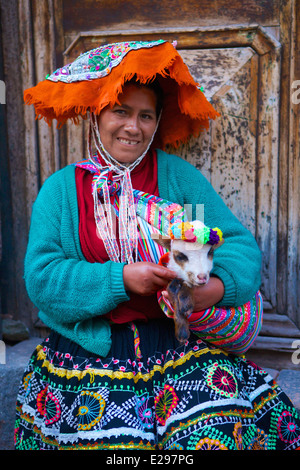 Ein Porträt einer Quechua-Frau in einheimischen Trachten hält ein Lamm in Cusco, die Anden, Peru, Südamerika Stockfoto