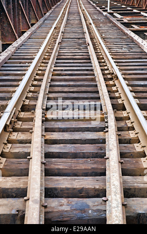 Eine Reihe von Eisenbahn Spuren führen in die Ferne über eine rostige Brücke. Stockfoto