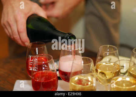 Man gießt Sekt in die Gläser Stockfoto