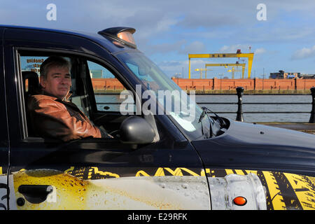 Großbritannien, Nordirland, Belfast, Billy Scott in seinem Black Cab vor der Samson und Goliath Gantry aus Krane Stockfoto
