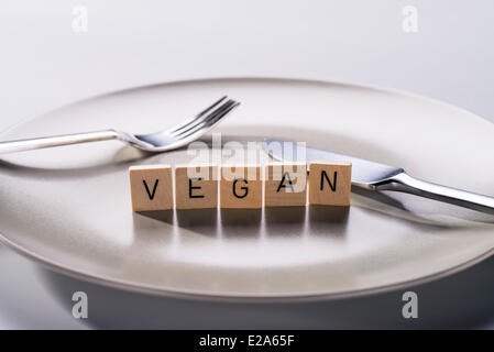 Teller mit Messer und Gabel und das Wort "Vegan" Stockfoto