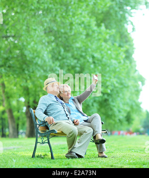 Älteres Ehepaar nehmen ein Selbstporträt im Park sitzt auf einer Holzbank Stockfoto