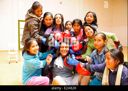 Peru, Cuzco, Cusco Provinz Mädchen rund um ihre Lehrer des Boxens während einer Selbstverteidigung-Sitzung in der Turnhalle der eines Stockfoto