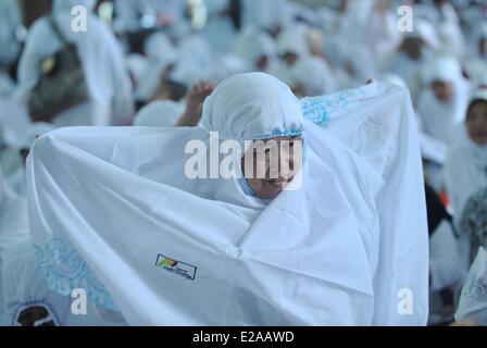 Jakarta, Indonesien. 18. Juni 2014. Eine indonesische muslimische Frauen trägt einen Schleier erhalten kostenlos, um der heilige Fastenmonat Ramadan in Sunda Kelapa Moschee in Jakarta, Indonesien, 18. Juni 2014 begrüßen zu dürfen. Bildnachweis: Agung Kuncahya B./Xinhua/Alamy Live-Nachrichten Stockfoto