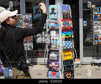 Eine asiatische Touristen sucht nach Berlin Postkarten in einem Shop für Touristen am Checkpoint Charlie in Berlin, 6. Juni 2014. Das Foto ist Teil einer Serie über den Tourismus in Berlin. Foto: Wolfram Steinberg dpa Stockfoto