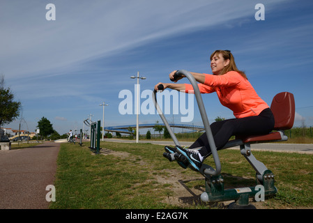 Frau mit outdoor-Fitness-Park-Rudergerät Stockfoto