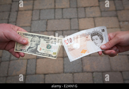 Menschen, die Austausch einer $10-Dollar-Rechnung für ein £10-Pfund-Note. Stockfoto