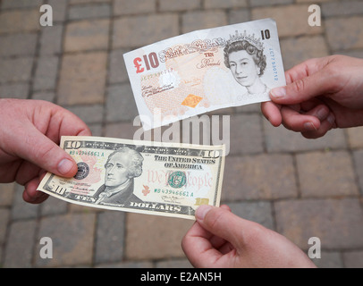 Menschen, die Austausch einer $10-Dollar-Rechnung für ein £10-Pfund-Note. Stockfoto