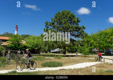 Frankreich, Gironde, d ' Arcachon, Cap Ferret, paar, Radfahren auf einem Feldweg vor einer Tanne mit einem Leuchtturm in der Stockfoto