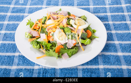 Ein frischer Salat aus grünen, Gurke und Karotten in einem weißen Teller Stockfoto