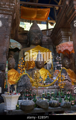 Buddha-Statuen sind in der historischen Angkor Zeit Wat Phu, gebaut von den Khmers in Champasak, Laos in orange Stoff drapiert. Stockfoto