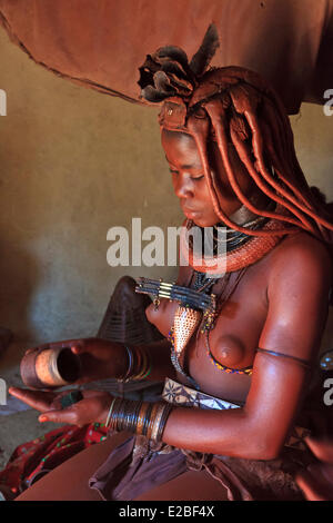 Namibia, Kunene-Region, Kaokoland oder Kaokoveld, Himba Frau im Dorf, Bantu-Ethnie, Körper mit Hämatit Ocker bedeckt Stockfoto