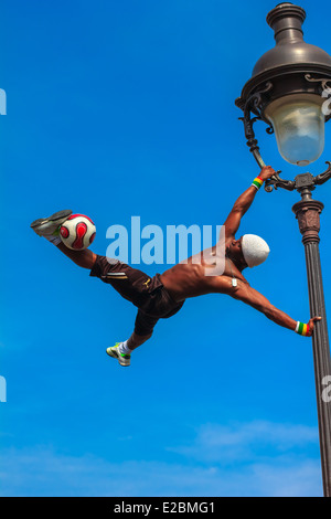 Unglaubliche Fußball Freestyle Iya Traore Laternenpfahl hängen und Jonglage einen Fußball vor Sacre Coeur Kirche Stockfoto