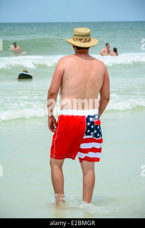 Ein Mann trägt seine patriotischen Sternenbanner Badehose am Strand am 4. Juli, USA Stockfoto