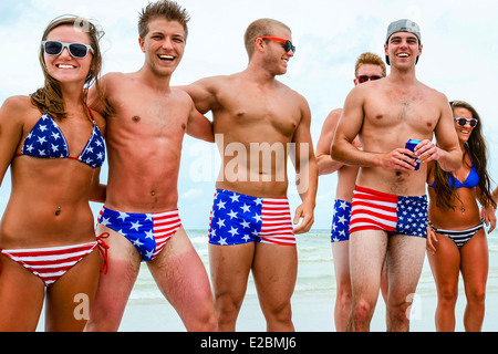 Eine Gruppe von patriotischen Hochschule-gealterte Männer & Frauen in Badeanzügen Sternenbanner strut ihre Sachen am Strand am 4. Juli Stockfoto