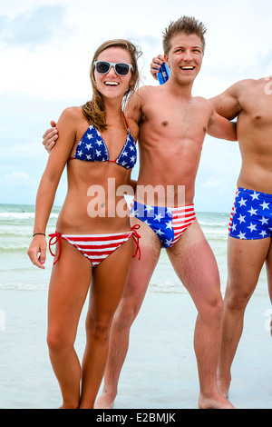 Eine Gruppe von patriotischen Hochschule-gealterte Männer & Frauen in Badeanzügen Sternenbanner strut ihre Sachen am Strand am 4. Juli Stockfoto