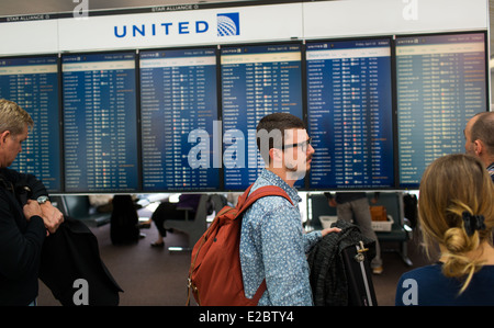 Die Passagiere einchecken die Abfahrtstafel für United Air Lines Flüge am O' Hare International Airport in Chicago, Illinois. Stockfoto