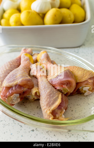 Hähnchenschenkel auf ein Backblech und frischem Gemüse Stockfoto